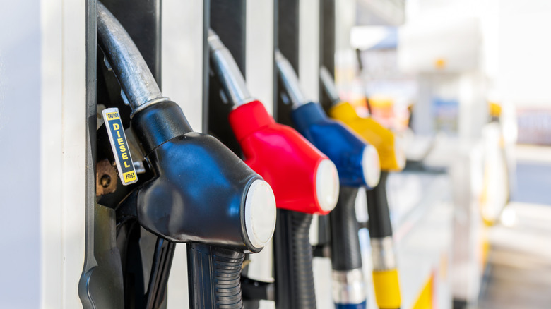 A close-up of some pumps on the hook at a gas station
