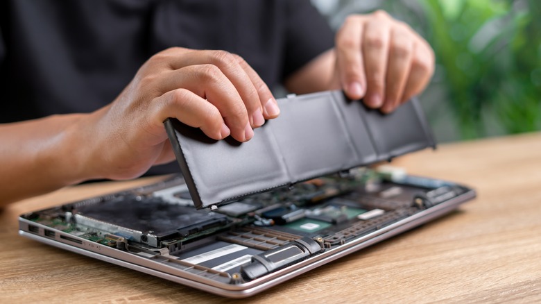 Man removing a laptop battery.