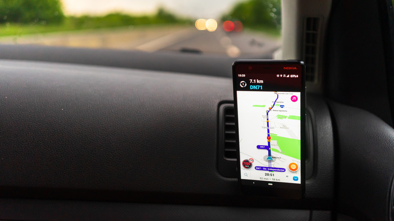 Waze app showing map on phone sitting on dashboard