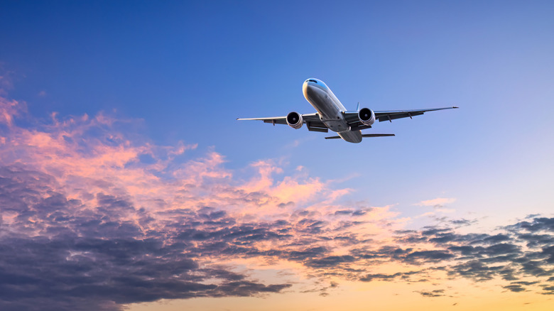 Plane flying in sunset