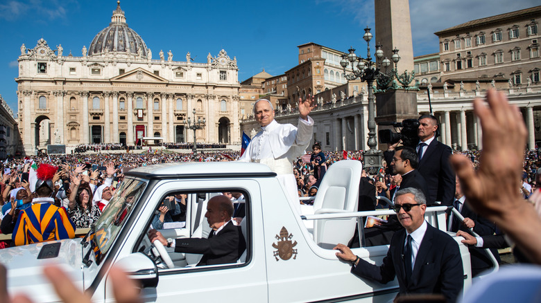 Pope Leo XIV waving from his vehicle.