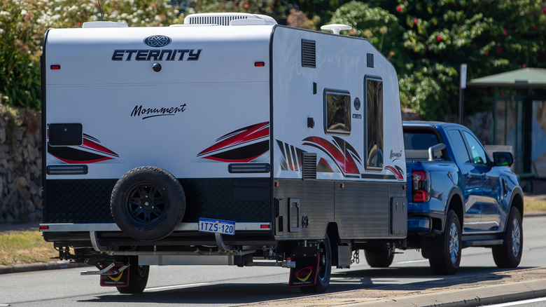 a blue pick-up truck pulling an Eternity Monument caravan