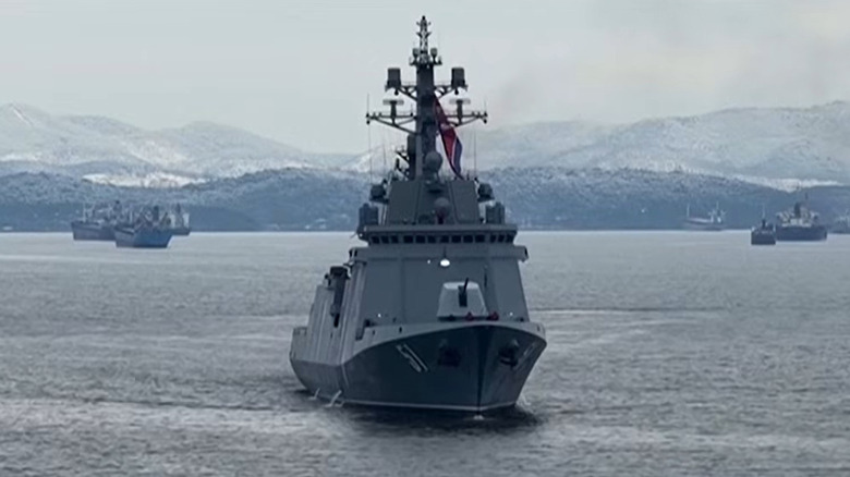 The North Korean destroyer Choe Hyon setting out to sea with snow covered hills in the background