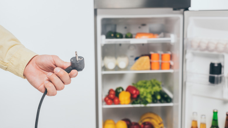 A man holding chord for a fridge