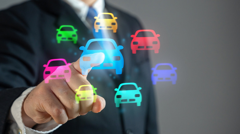 A person tapping on a virtual illustration of cars