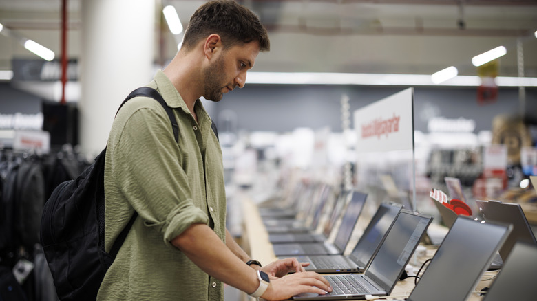 A man testing a laptop at an electronics store