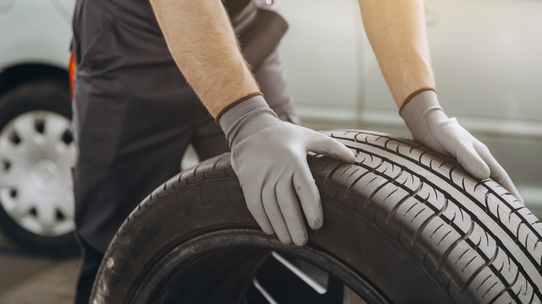 Closeup of a technician holding a car tire