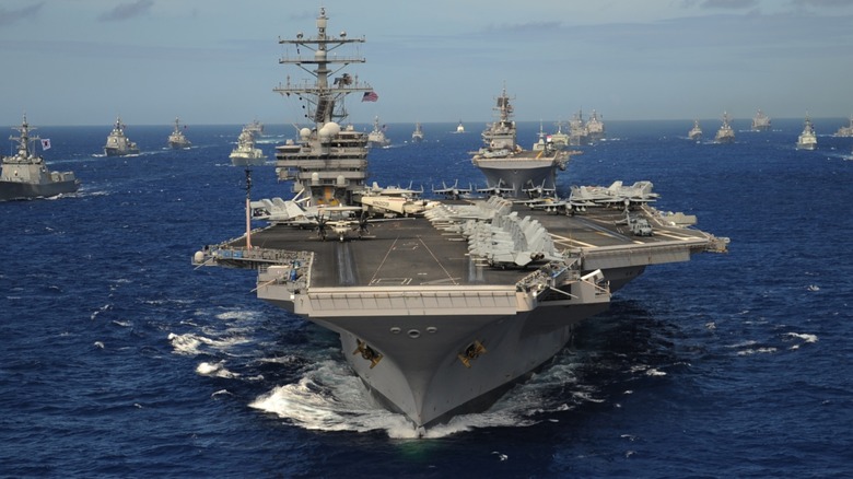 Nimitz-class aircraft carrier USS Ronald Reagan leading multiple ships in the sea