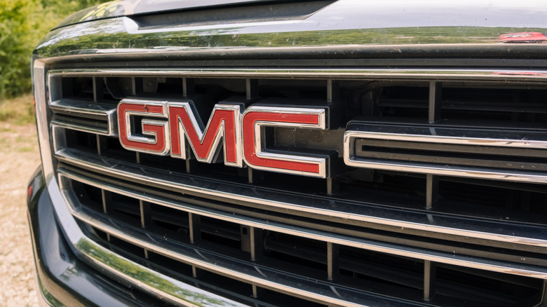 Close-up of a GMC logo on a large silver car grille