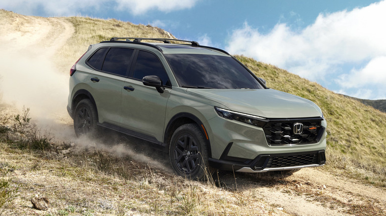 A mossy green 2026 Honda CR-V TrailSport trim on a dirt road