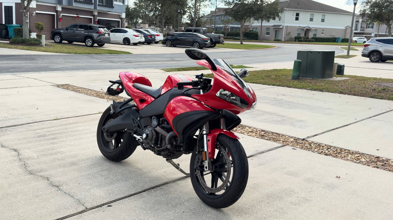 A red Buell 1125R parked on a driveway, front 3/4 view