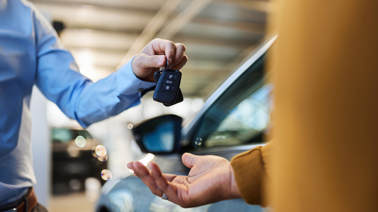 A renter receiving their car keys from a salesman