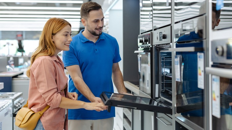 Salesman showing customer major appliance