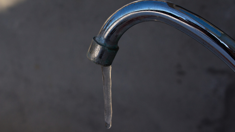 An icicle on the end of a silver faucet