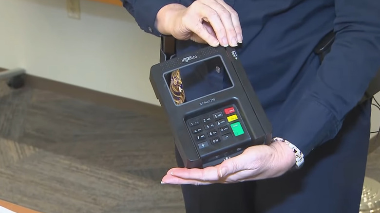 A woman holding a credit card skimmer