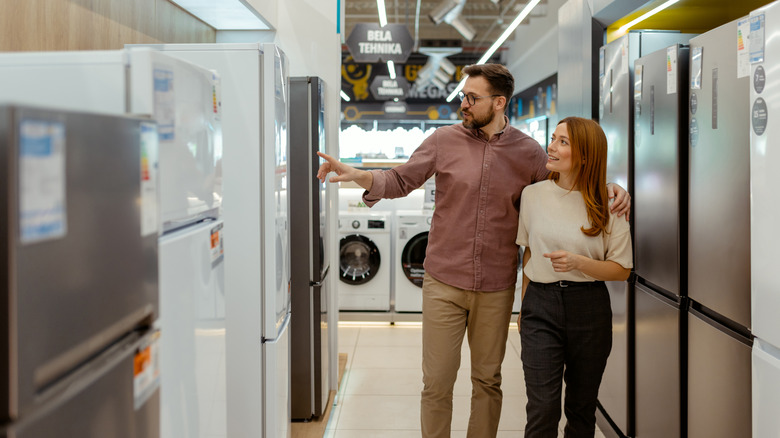 Couple browsing refrigerators at a store