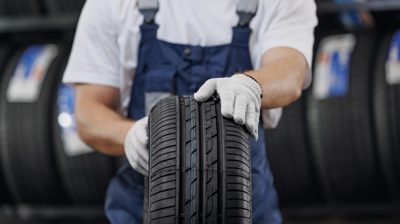 Tire technician rolling new tire