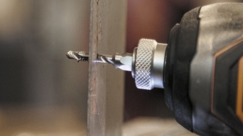 Using the Klein Tools drill and tap combo to cut threads in a thin metal plate.