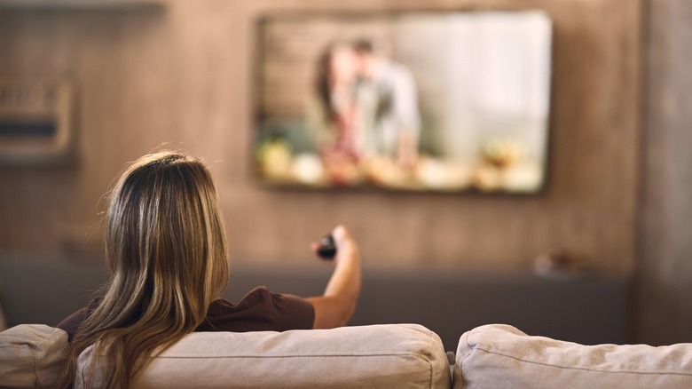 Person sitting on a couch watching a television show