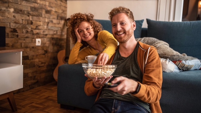 People eating popcorn while watching television
