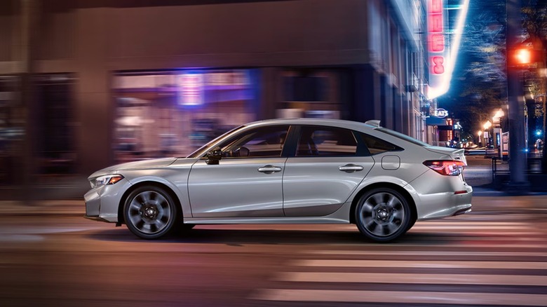 2026 Honda Civic driving through a city landscape