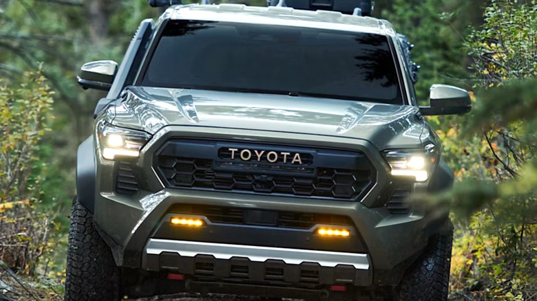 2026 Toyota Tacoma driving through a forest landscape