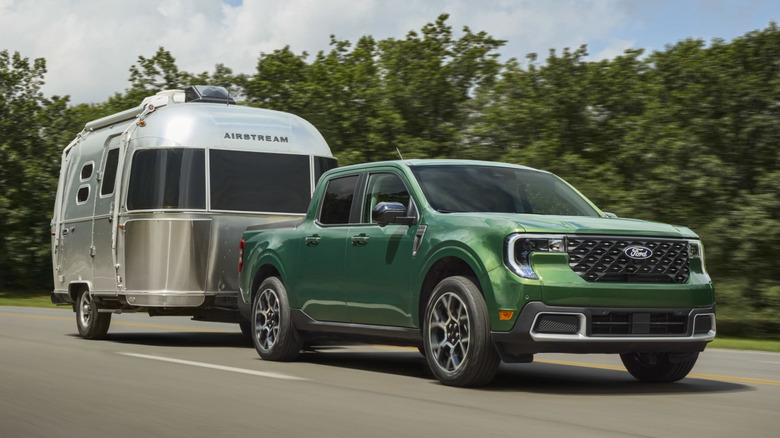 Front 3/4 view of green Ford Maverick towing Airstream trailer.