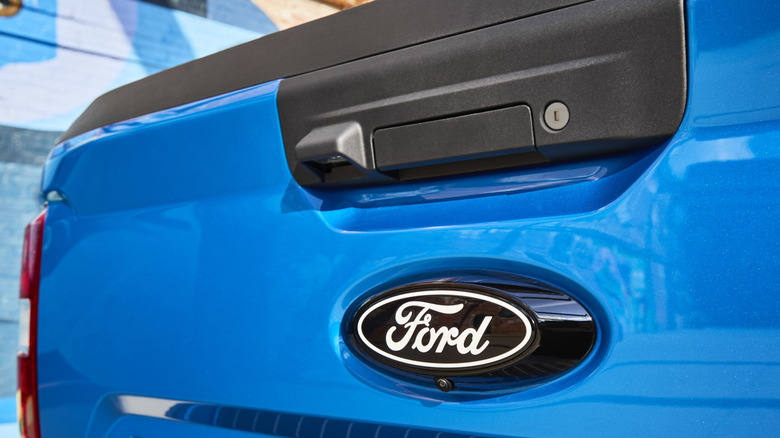 Close up view of Ford emblem on blue Ford Maverick tailgate.