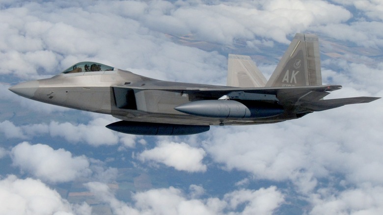 A F-22 Raptor flying over cloudy skies