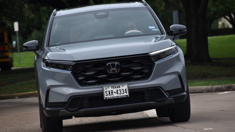 A front-end view of a gray Honda CR-V driving.