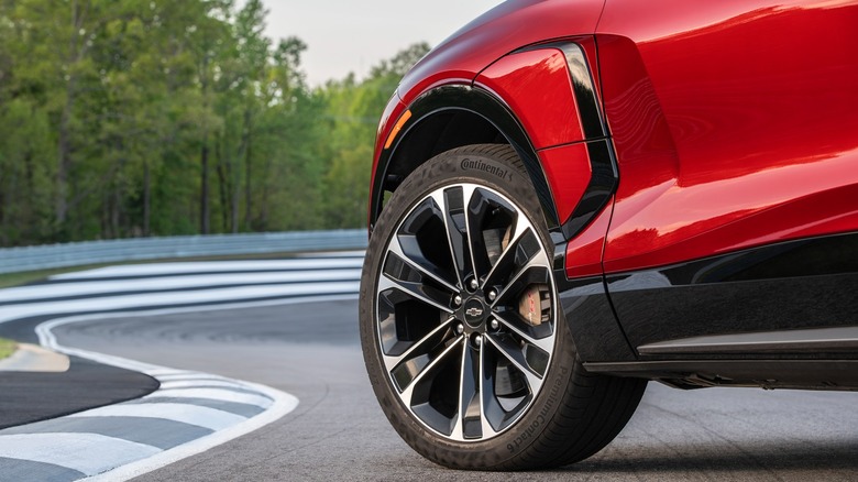 Close-up of a red Chevrolet Blazer EV front tire parked on a track.