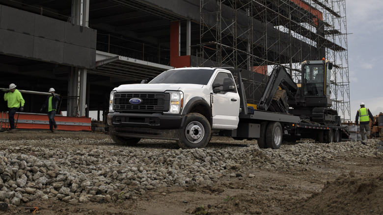A Ford truck equipped with a flatbed being used on a construction job site