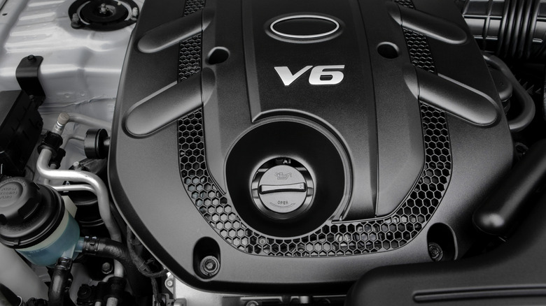 A brand new  modern V6 engine with an engine cover displaying a V6 badge