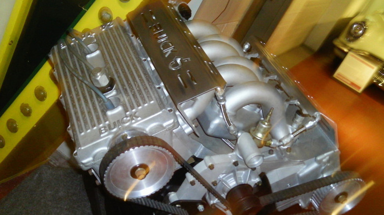 A 1980s Buick V6 engine sitting in a workshop.