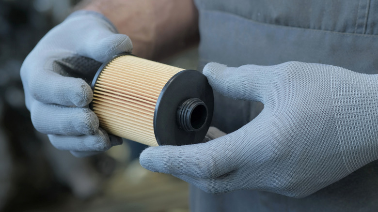Mechanic holding oil filter