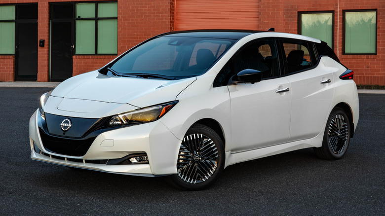 A white 2025 Nissan Leaf parked in front of a building