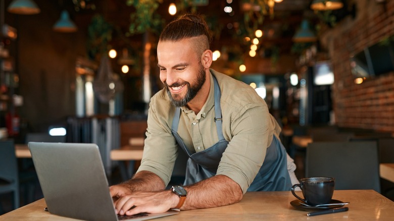 a person using a small laptop in a coffee shop