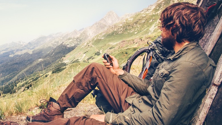 Hiker sitting down on mountainside