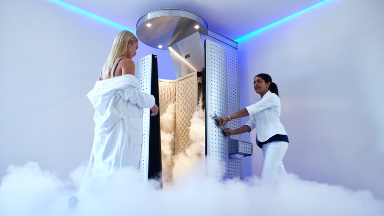 Woman entering a full body cryogenic freezing tube