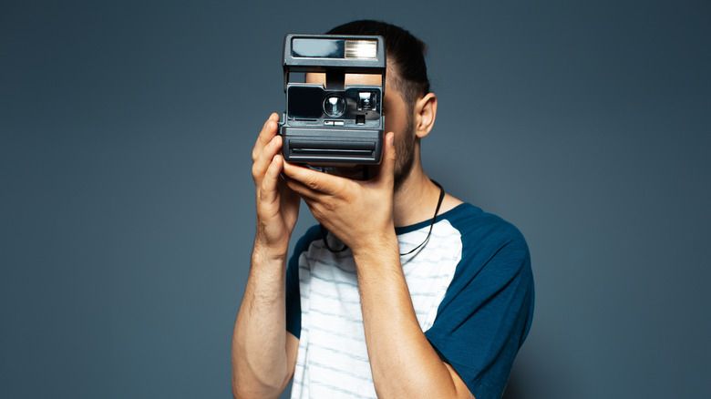 Person using Polaroid camera