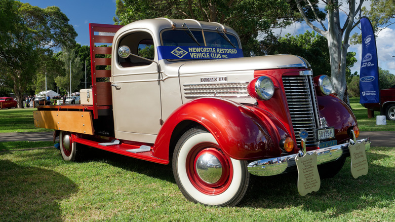 1937 Oldsmobile flatbed truck in Australia, front 3/4 view, two-tone white and red exterior