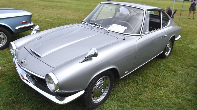 Silver BMW 1600 GT parked on grass at a car show