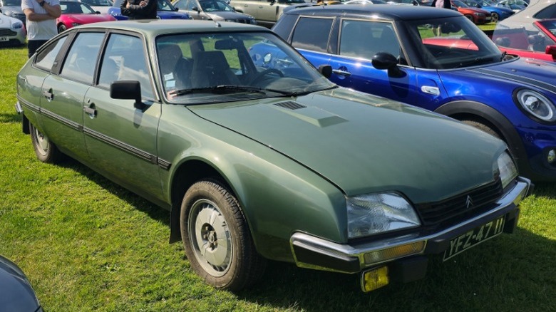 A green Citroën CX parked on grass at a car show.