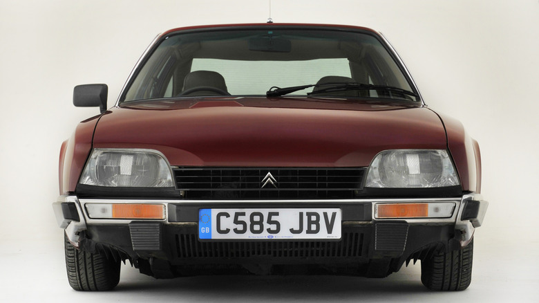 Front view of a dark red Citroën CX in front of a white backdrop.