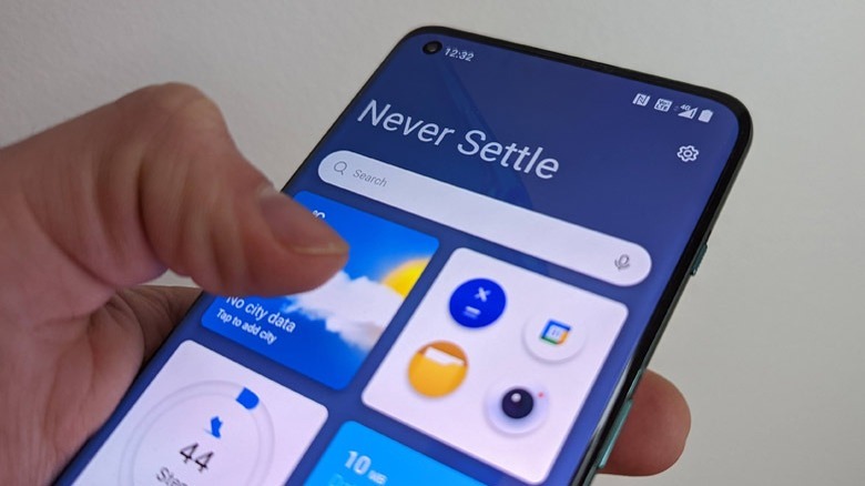 OnePlus 10 Pro 5G in hand with thumb at touchscreen