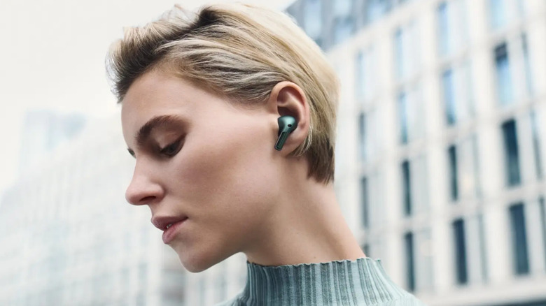 Person wearing green OnePlus Buds Pro 2