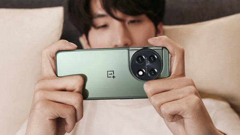 person holding green OnePlus 11 