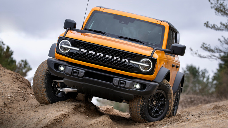 Front view of yellow 2026 Ford Bronco off-roading on dirt hills.