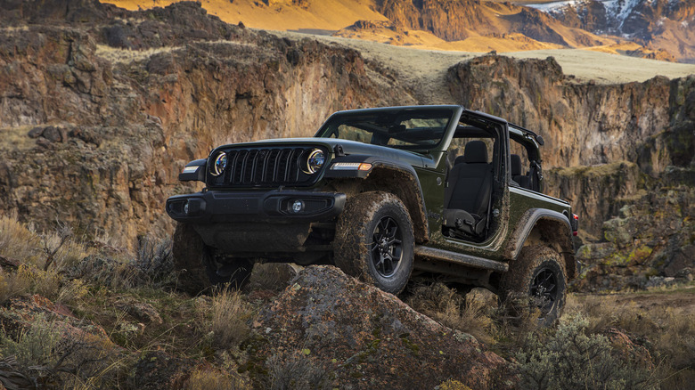 Front 3/4 view of 2024 Jeep Wrangler Willys parked in mountains.