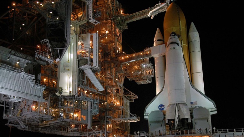 Space Shuttle Discovery sitting on the launchpad at night